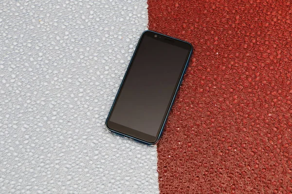 Close-up of a smartphone on a red-blue background. — Stock Photo, Image