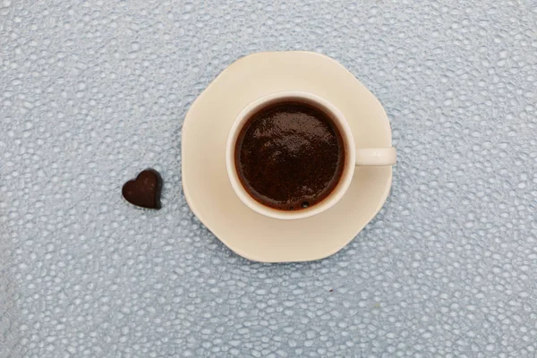 クローズアップ-コーヒーカップ、 2つのハート型のチョコレートの横にある. — ストック写真