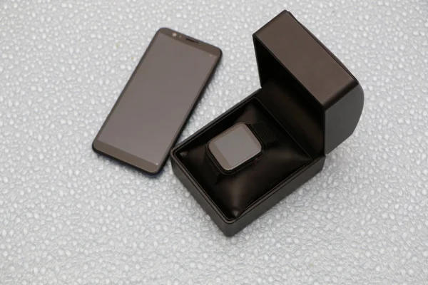Smartphone e smartwatch in una confezione regalo nera — Foto Stock