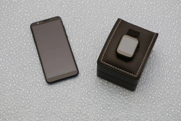 Smartphone y smartwatch en una caja de regalo negra — Foto de Stock