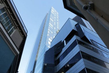 Ofis binaları - iş bölgesindeki modern gökdelenlerin alt manzarası. Mavi gökyüzü arkaplanı.