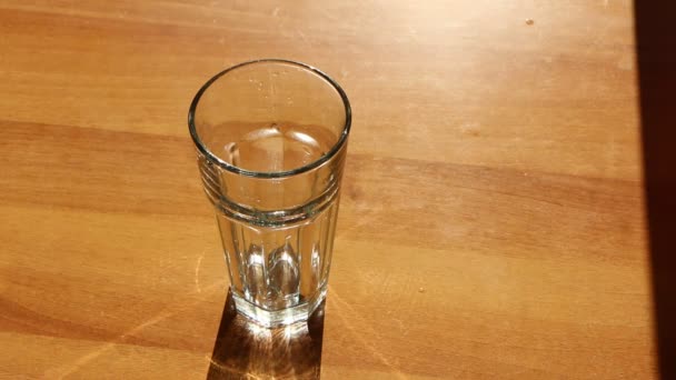 Wasser Wird Aus Einer Glaskanne Eine Transparente Glasschale Gegossen Holzhintergrund — Stockvideo