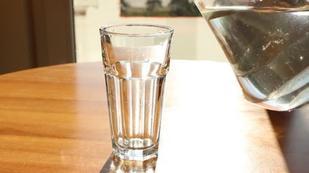 Eau Est Versée Une Cruche Verre Dans Une Tasse Verre — Video