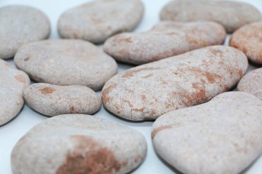 Tasarım elementi - gri deniz taşları beyaz arka planda serili.