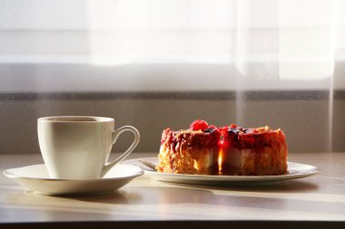 Kavram - masaya aromatik kahve ve kek serpiştirilmiş bir fincanın yakın çekimi.