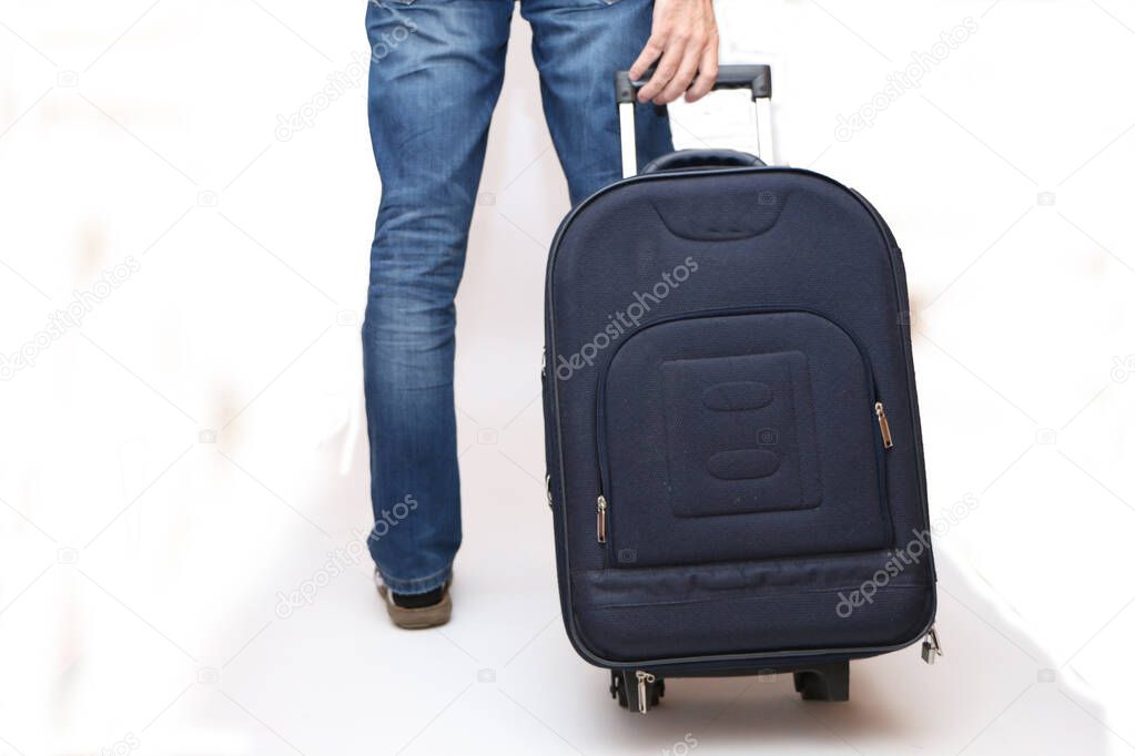 A man goes on vacation and pulls a suitcase from the back.