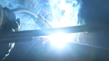 Çok yetenekli bir kaynakçı, bir fabrikada metal bir yapıyı kaynak yapar. Kaynak işlemi 135.
