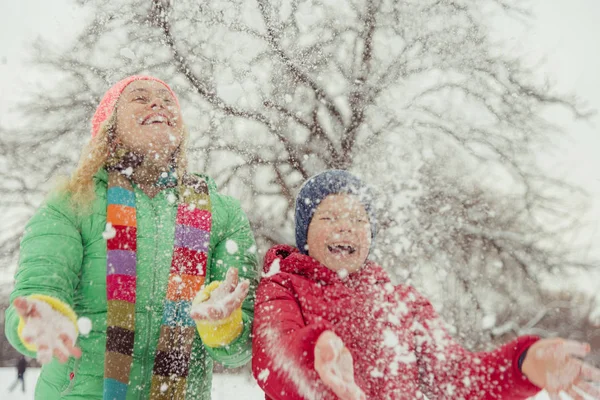 Inverno. Mamma con un bambino che gioca con la neve . — Foto Stock