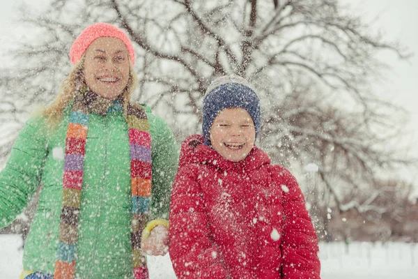 Inverno. Mamma con un bambino che gioca con la neve . — Foto Stock