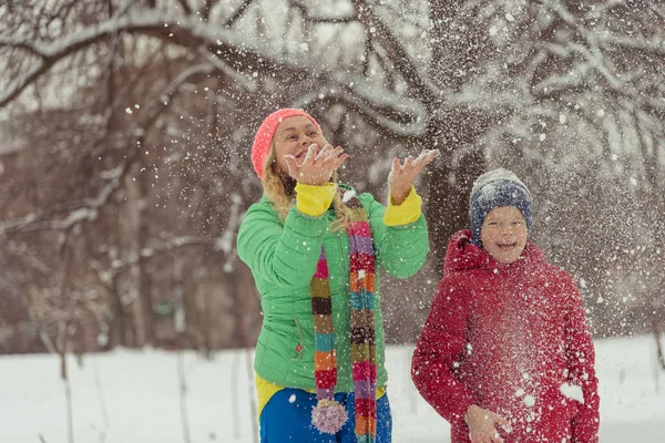 Inverno. Mamma con un bambino che gioca con la neve . — Foto Stock