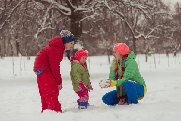 Inverno. Mamma con un bambino che gioca con la neve . — Foto Stock