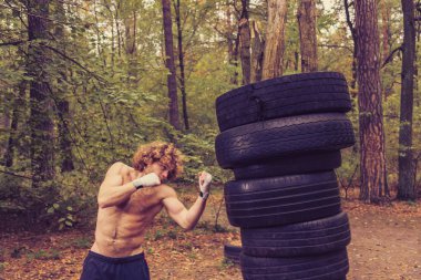 Ev yapımı armut, araba lastikleri yapılan boks. Savaşçı tekme yerine getirir.