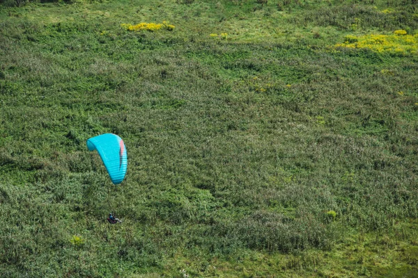 Skärmflygning. En paraglider flugor över fältet. — Stockfoto