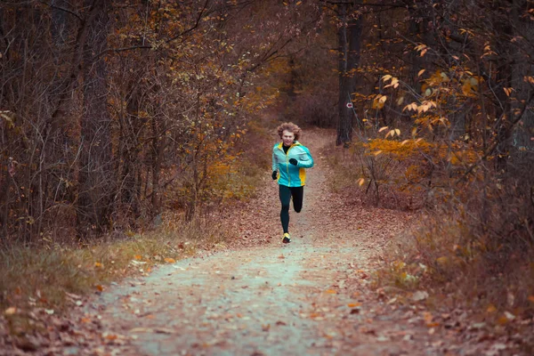 Herbstpark. Morgenlauf. Mann in Sportbekleidung joggen. — Stockfoto