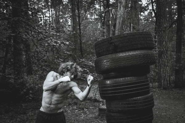Boxeo de pera casera, hecho de neumáticos de coche. Combatiente cumple patada — Foto de Stock