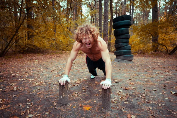 Zelfgemaakte speeltuin. Atleet zwaait de armspieren. — Stockfoto