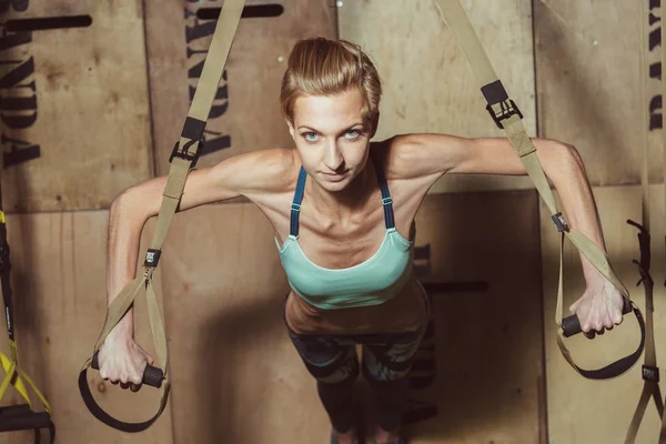 TRX. Menina fazendo exercícios no salão — Fotografia de Stock