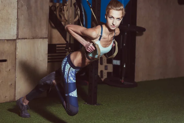 TRX. Menina fazendo exercícios no salão — Fotografia de Stock