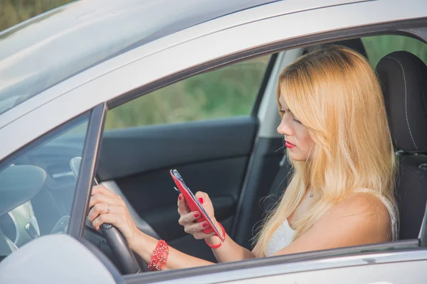 女の子ドライバー。運転中に携帯電話で話している女性. — ストック写真