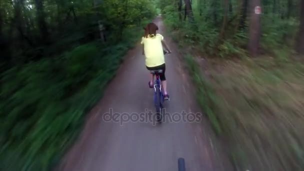 Гірський велосипед. Дівчина катається на гірському велосипеді через ліс — стокове відео