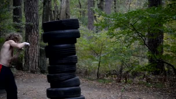 Boxing homemade pear, made from car tires. Fighter fulfills kick. — Stock Video