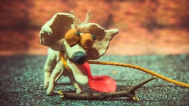 Onun ağzına bir sopa tutan animasyonlu hamuru köpek