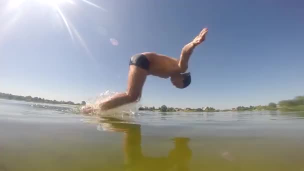 Mann läuft mit Anlauf in den Teich — Stockvideo