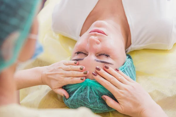 Gezicht massage. Meisjes doen gezicht massage in de schoonheidssalon — Stockfoto