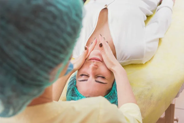 Gezicht massage. Meisjes doen gezicht massage in de schoonheidssalon — Stockfoto