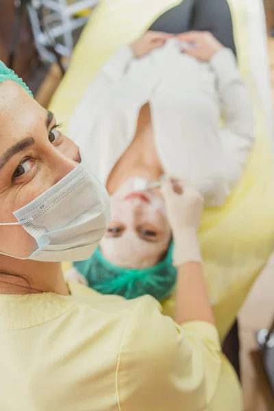 Kosmetiska ansiktsmask. Flicka i en skönhetssalong gör en mask för f — Stockfoto