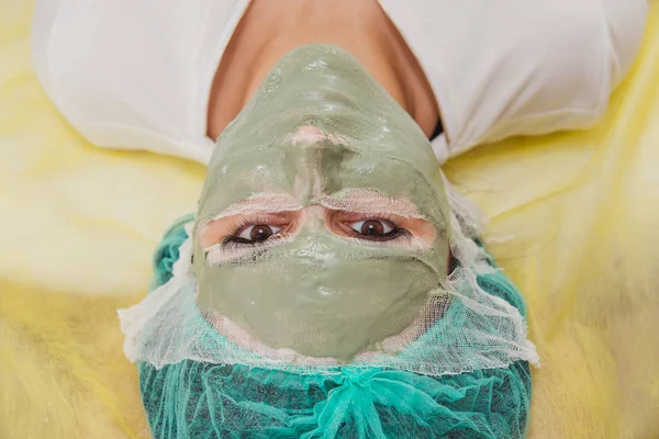 Cosmetic face mask. Girl in a beauty salon make a mask for the f — Stock Photo, Image