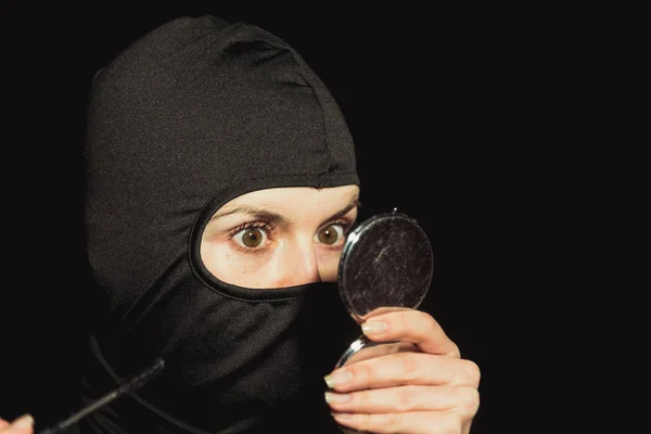 Mädchentäter. das Mädchen in schwarzer Maske lackiert Wimpern. — Stockfoto