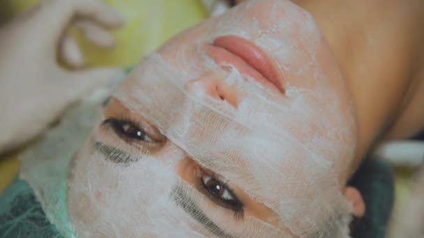 Косметична маска для обличчя. Дівчина в салоні краси робить маску для обличчя — стокове відео