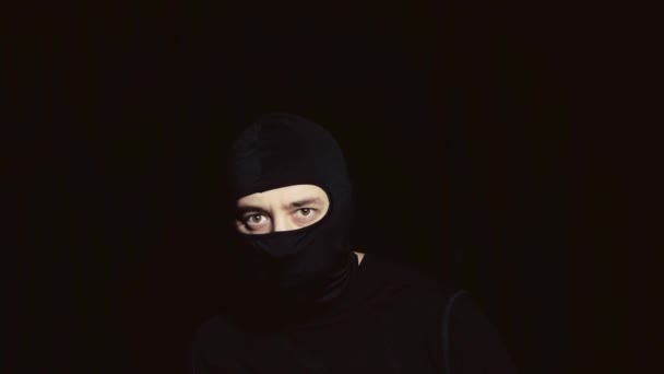 En man i en svart mask med en kniv i handen. — Stockvideo