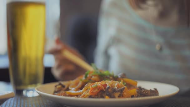 Fideos. La chica come fideos con palillos — Vídeos de Stock