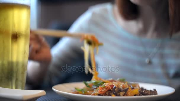 Fideos. La chica come fideos con palillos — Vídeos de Stock