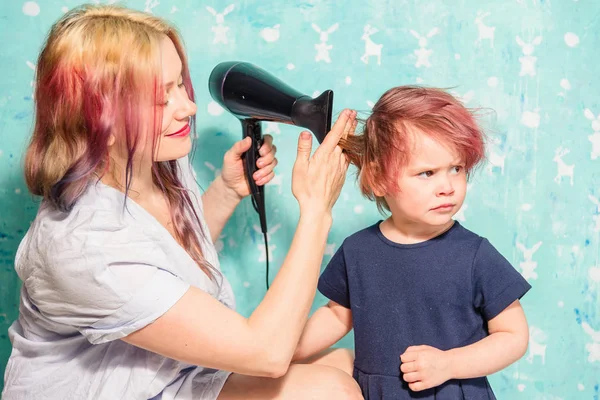 Мама сушит дочери волосы. — стоковое фото