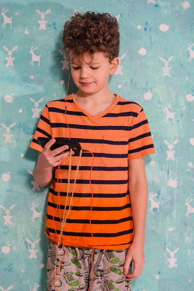 Hareket eden telefon. Bir çocuk onun cep telefonu müzik dinliyor. — Stok fotoğraf
