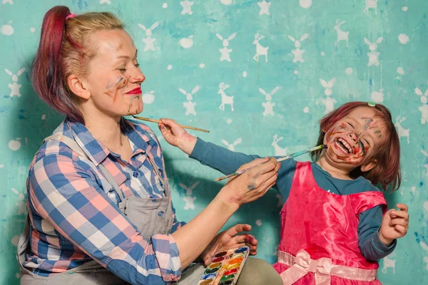 Mamá y el niño dibujan pinturas de la cara del otro . —  Fotos de Stock