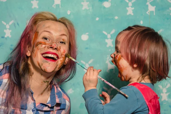 Mutter und Kind malen sich gegenseitig die Gesichter auf. — Stockfoto