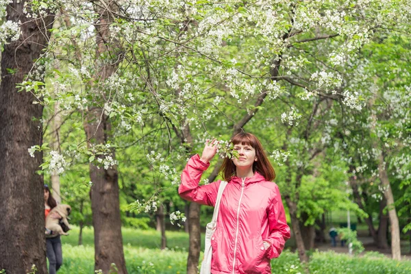 Primavera. La chica está de pie cerca de un árbol floreciente . —  Fotos de Stock