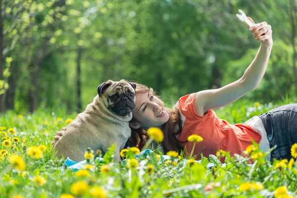 Selfy. La chica toma un teléfono y un perro . —  Fotos de Stock