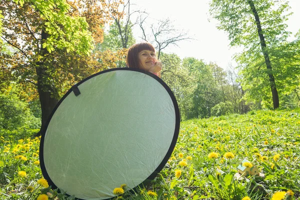 Reflector. La chica sostiene un reflector de luz . — Foto de Stock