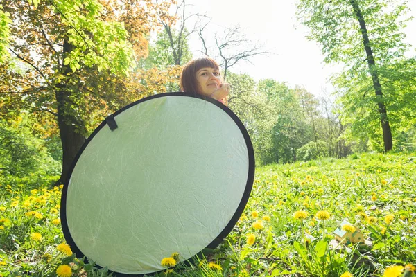 Refletor. A menina está segurando um refletor de luz . — Fotografia de Stock