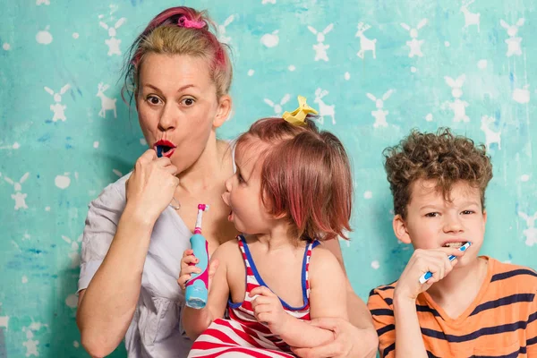 Cepillo de dientes. Mamá, hijo e hija se cepillan los dientes — Foto de Stock