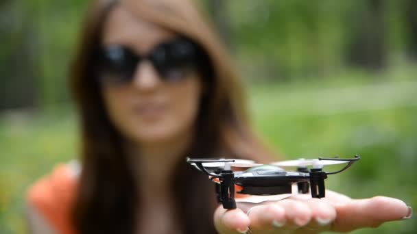 Quadrokopter. das Mädchen hält einen kleinen Quadrocopter in der Hand — Stockvideo