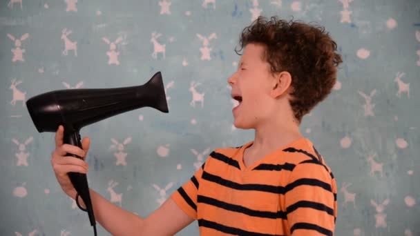 Niño secándose la cabeza con un secador de pelo — Vídeos de Stock