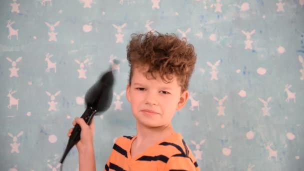 Rapaz a secar a cabeça com um secador de cabelo — Vídeo de Stock