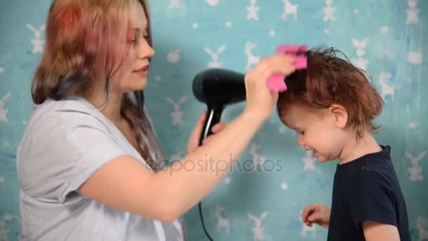 Мама сушит дочери волосы. — стоковое видео