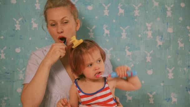Zahnbürste. Mutter lehrt kleine Tochter ihre Zähne zu putzen — Stockvideo